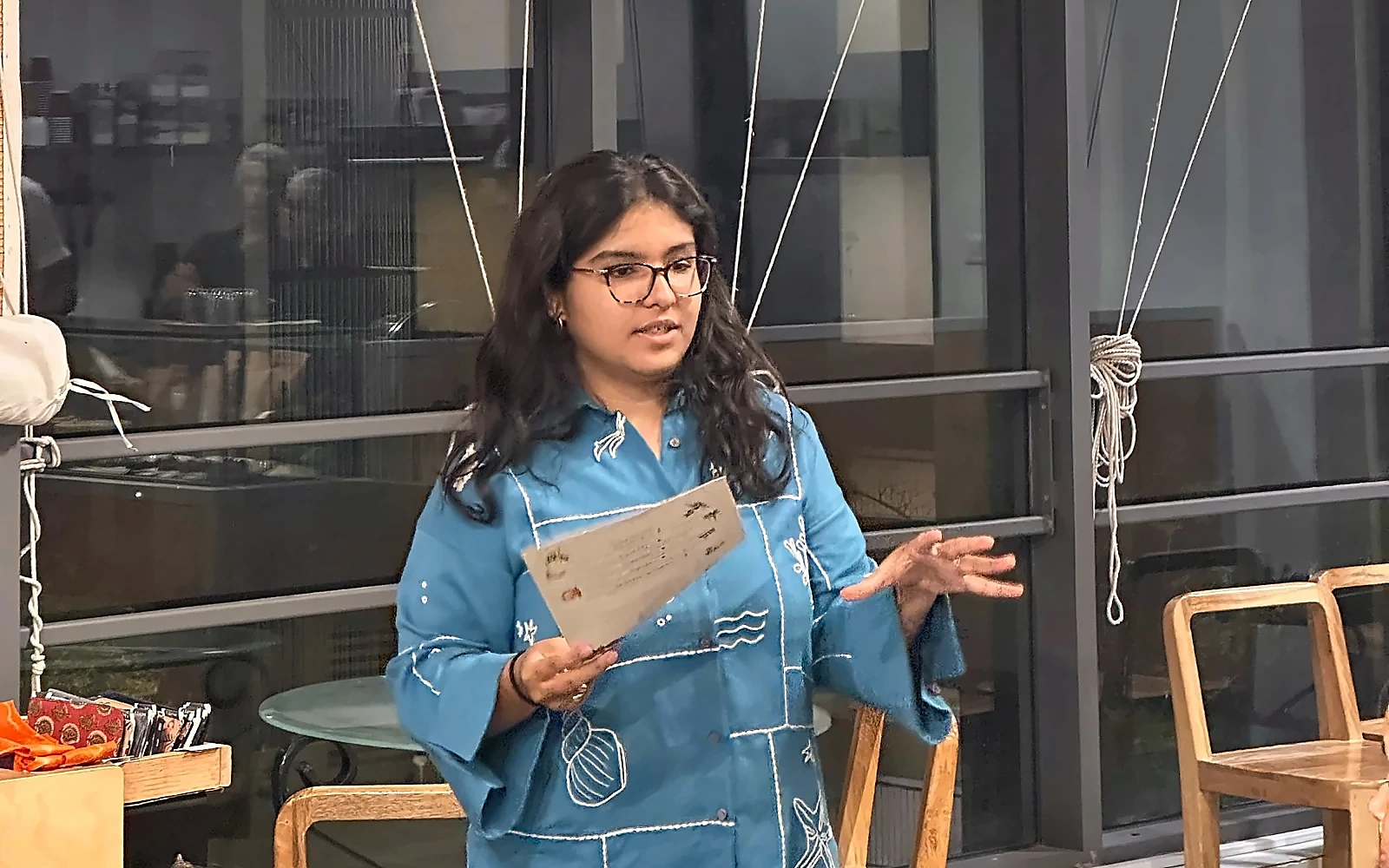 Ishika presenting at a community event, sharpened with a head-safe crop